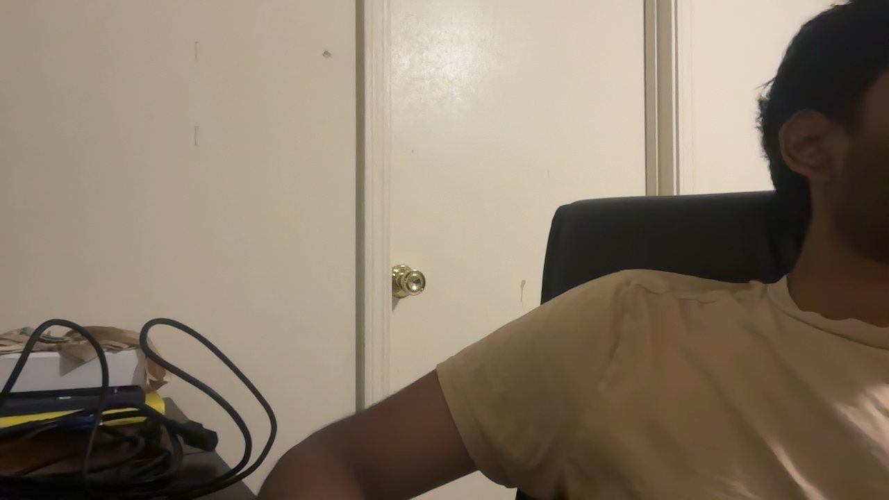 Webcam photo of Akshay at a desk, turned away from the screen